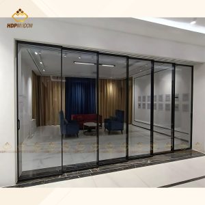 Hệ cửa lùa slim 6 cánh vận hành lùa 2 bên, tạo lối đi trung tâm sang trọng cho khu vực tiếp khách.