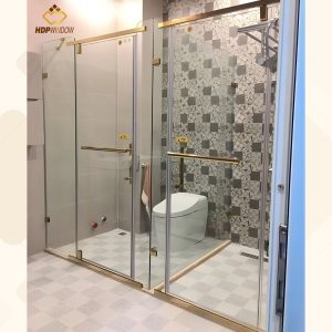 Mẫu phòng tắm đôi với cửa mở quay, tay nắm dài và phụ kiện mạ PVD vàng.