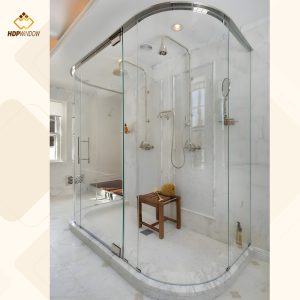 Mẫu phòng tắm kính hình chữ nhật được uốn cong bo góc, lắp trên bệ đá.