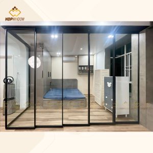 Hệ cửa lùa slim 5 cánh làm vách ngăn di động giữa phòng ngủ và phòng làm việc.