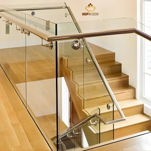 Mẫu cầu thang kính tay vịn inox kết hợp với bậc thang ốp gỗ tự nhiên.