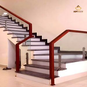 Mẫu cầu thang kính tay vịn gỗ vuông với bậc thang đơn giản, hiện đại.