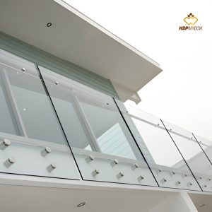 Minh họa chi tiết lan can kính ban công không trụ, sử dụng pad inox 304 bắt bên hông dầm.